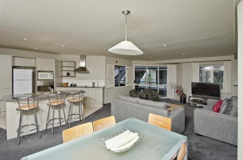 a kitchen and living room with a table and chairs at Pavilion Beachfront Apartments in Mount Maunganui
