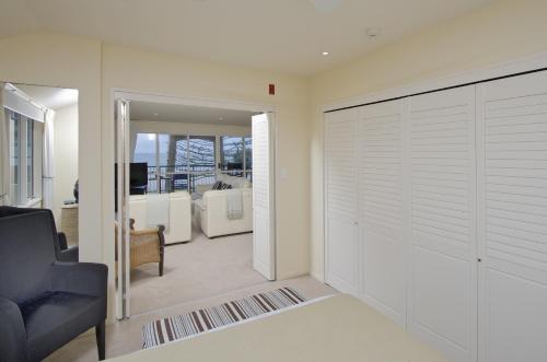a living room with a sliding garage door and a couch at Pavilion Beachfront Apartments in Mount Maunganui