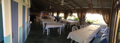 a restaurant with tables and white tables and chairs at Cita del Sol City Apartments in Cabarete
