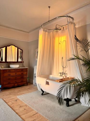 bagno con vasca, lavandino e specchio di Stylish elegant two bedroom apartment overlooking Southsea Common and the Solent a Portsmouth