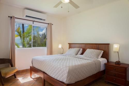 a bedroom with a bed and a large window at Villas Iguana A-14 Beachfront Condo in Iguana