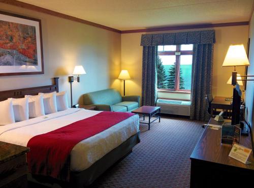 a hotel room with a bed and a chair and a window at Canal Park Lodge in Duluth