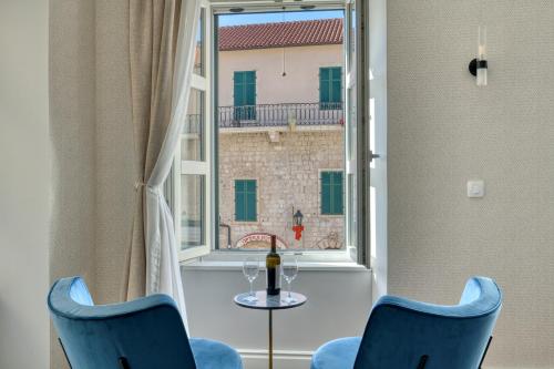 Habitación con 2 sillas, mesa y ventana en Hive Luxury Suites by MN Property, en Kotor