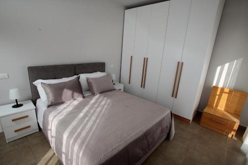 a bedroom with a bed and a white cabinet at NOVA Sea View Apartments in Durrës