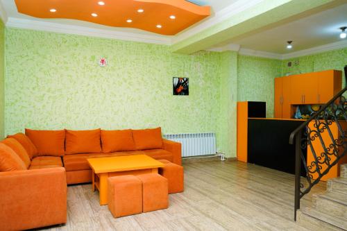 sala de estar con sofá naranja y mesa en Royal Rest Townhouse, en Dilijan