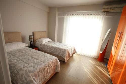 a bedroom with two beds and a window at NOVA Sea View Apartments in Durrës