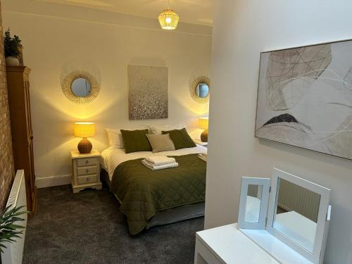 a bedroom with a bed and two mirrors on the wall at High Street Apartment in Whitchurch