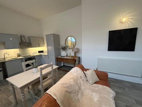 a living room with a couch and a table at High Street Apartment in Whitchurch