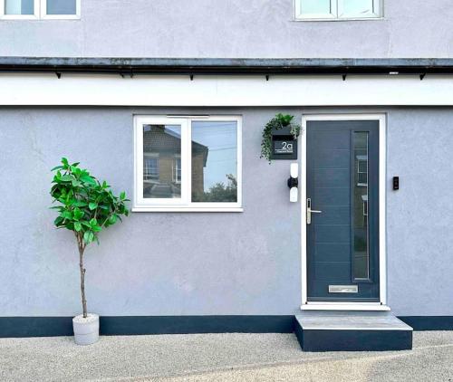 una casa con una puerta azul y una maceta en The Modern Smart Home en Great Warley Street