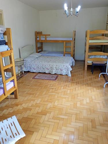 um quarto com 2 camas e piso em madeira em Casarão ao lado do Hotel Majestic em Águas de Lindóia