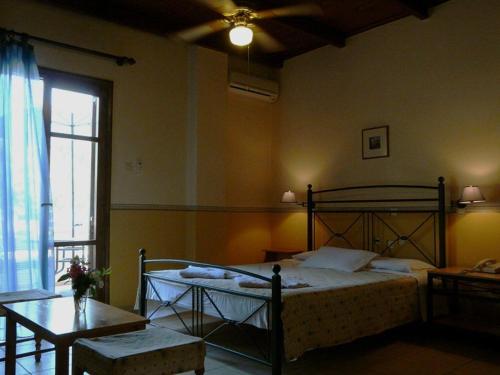 1 dormitorio con cama, mesa y ventana en Alexandros Studios & Apartments, en La Canea