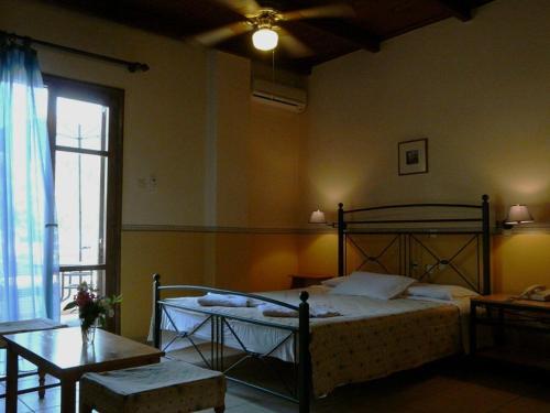 a bedroom with a bed and a table and a window at Alexandros Studios & Apartments in Chania Town