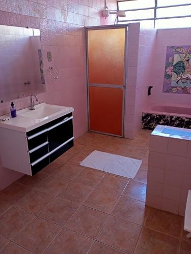 y baño con lavabo, ducha y espejo. en Casarão ao lado do Hotel Majestic en Águas de Lindóia