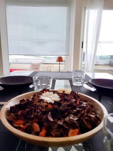 a bowl of food sitting on a table at Penthouse/ Rooftop Ocean view in Le Havre