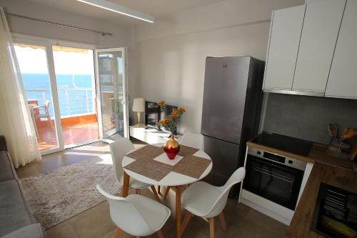 a kitchen with a table and chairs and a kitchen with a balcony at NOVA Sea View Apartments in Durrës