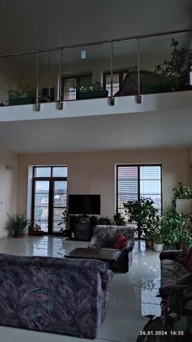 a living room with two couches and a flat screen tv at Villa Homestay Nad Helmrovkou in Prague