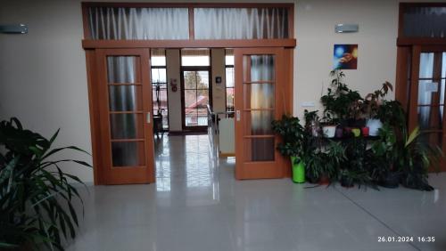a lobby with two doors and potted plants at Villa Homestay Nad Helmrovkou in Prague