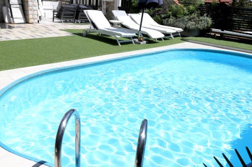 una gran piscina azul con sillas en un patio en Apartments Skandi1, en Malinska