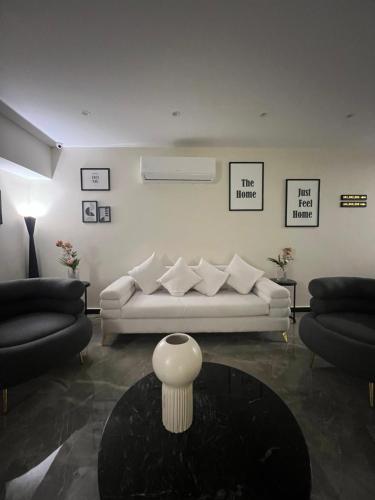 a living room with a white couch and a table at The Home Boutique Hotel Pyramids Inn in Cairo