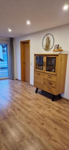 a living room with a large wooden cabinet and a wooden floor at Zum weißen Stein in Bad Arolsen