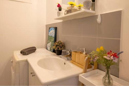 La salle de bains est pourvue d'un lavabo et d'un vase de fleurs. dans l'établissement * Le Provençal * cosy flat 3 min walk from the sea, à Nice