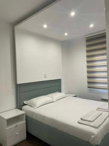 sypialnia z dużym łóżkiem i białą ścianą w obiekcie M Lux Apartment Zlatibor w mieście Zlatibor