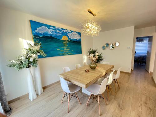une salle à manger avec une table et des chaises en bois dans l'établissement Superbe villa à 2 km centre ville de Colmar, à Horbourg-Wihr