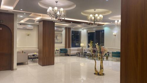 a lobby with a table and chairs and chandeliers at شقق راحتي هنا 2 in Riyadh