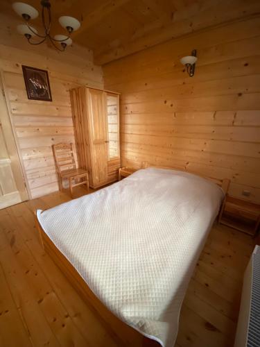 a bedroom with a bed in a wooden room at Nowica 71 Dom Jodłowy in Nowica