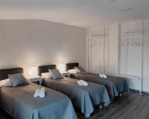 um quarto com três camas com toalhas em Svečių namai Žara em Tytuvėnai
