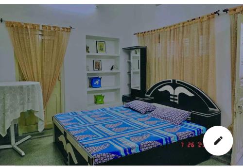 ein Schlafzimmer mit einem Bett mit einer Decke darauf in der Unterkunft Cheerful in Kānpur