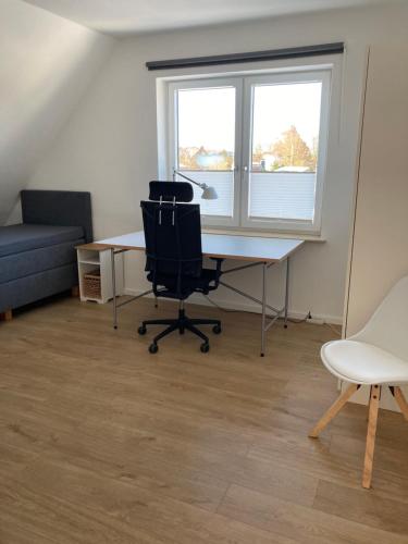 an office with a desk and a chair and a window at Ferienwohnung kleines Glück in Lübeck