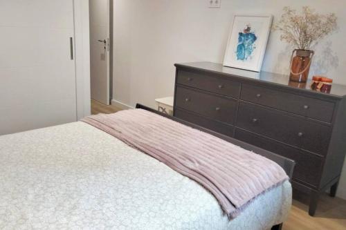 a bedroom with a bed and a dresser at Apartamento Playa del Con in Moaña