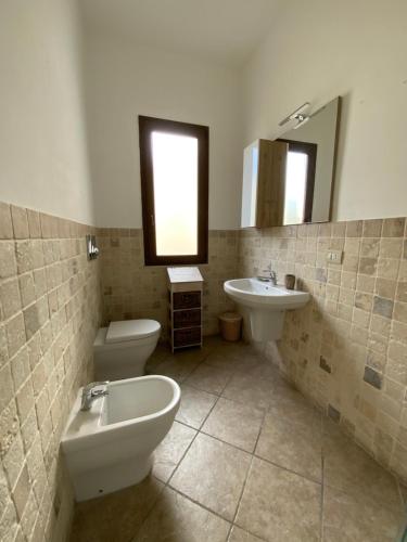 a bathroom with a toilet and a sink at Casa Deloy in Elmas