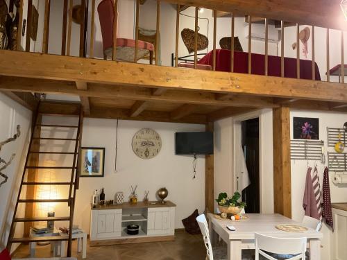 a room with a loft bed with a table and a dining room at La casetta di Vany in Nova Siri