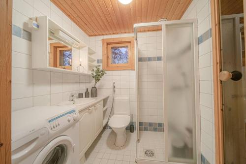 a bathroom with a washing machine and a toilet at Koto Lodge - Yllästunturi in Äkäslompolo
