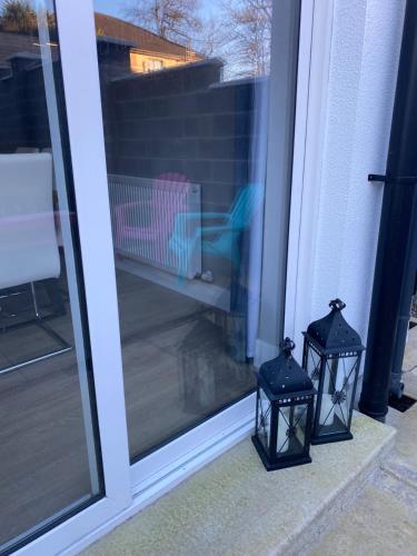 two lights on a porch next to a sliding glass door at Home in Kilmuckridge in Wexford