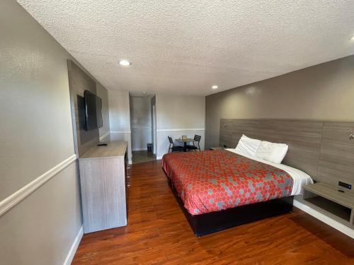 a hotel room with a bed and a television at SimpleStay Suites - Downtown San Bernardino in San Bernardino