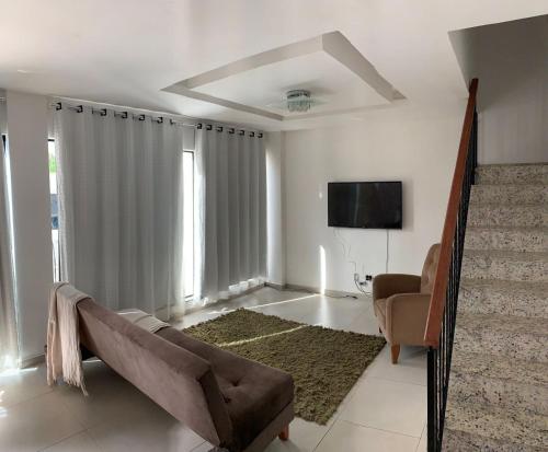 een woonkamer met een bank en een tv bij RB hospedagem in Cabo Frio