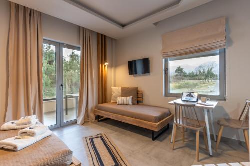 a bedroom with a bed and a desk and a window at Olympus Pantheon Luxury Rooms in Plaka Litochorou