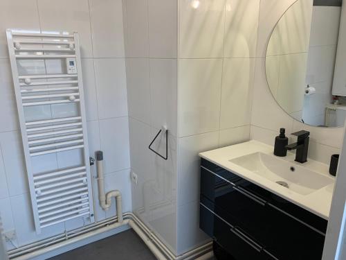 a bathroom with a sink and a shower with a mirror at Le courant d’air in Fort-Mahon-Plage
