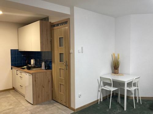 a kitchen with a table and a table and a door at METRO APARTMENT in Bielsko-Biała