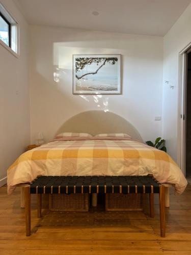 a bedroom with a bed with a yellow and orange comforter at 'NEL' - Rye Beach Studio Retreat in Rye