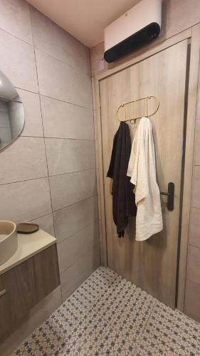 La salle de bains est pourvue d'une porte avec un lit et un lavabo. dans l'établissement Les Oliviers : Studio spacieux belle vue mer, Clim, à Port-Vendres