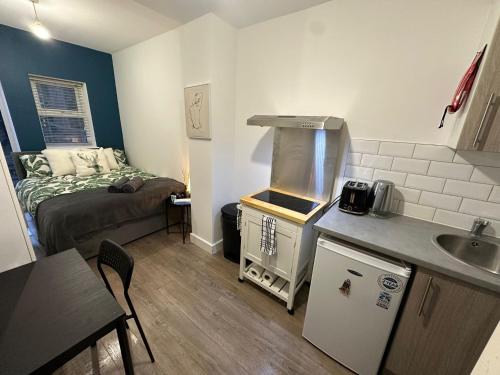 a small kitchen with a sink and a bed in a room at Halloway Guest Studio 54 in London