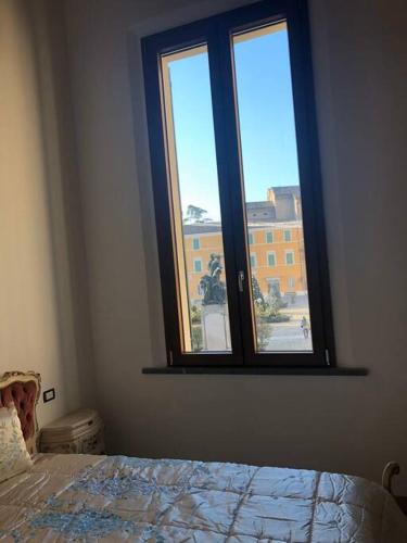 um quarto com uma cama e uma janela em palazzo piazza centrale em Bagnacavallo
