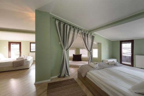 a large bedroom with a large bed with curtains at Villa Kaja Bansko in Bansko