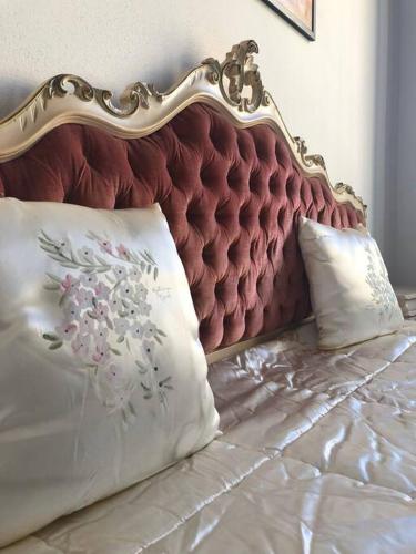 a bed with a red headboard and two pillows at palazzo piazza centrale in Bagnacavallo