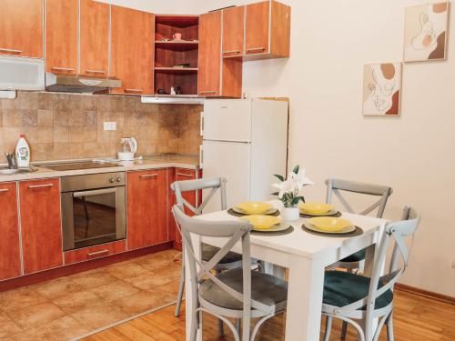 a kitchen with a table with chairs and a white refrigerator at Apartman Mia in Risan