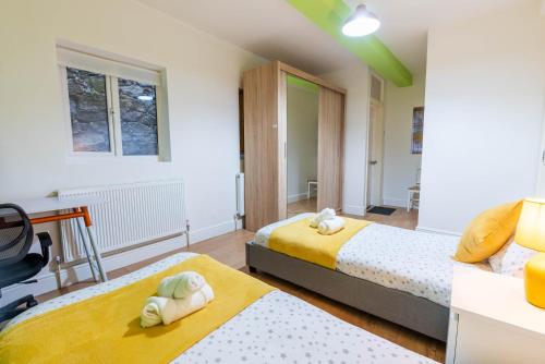 een slaapkamer met 2 bedden en een bureau bij 1 bedroom flat with 3 beds,Luton Town and station F3 53 in Luton